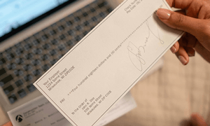 A Person's Hand Holding a Check