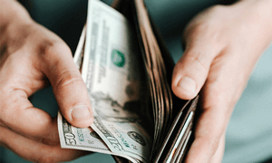 Crop man getting dollars from wallet